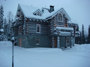 log cabin covered in snow