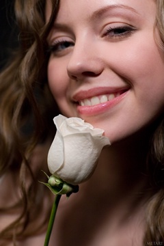 (e) holding a white rose, smiling